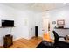 Bright office boasts hardwood floors, a ceiling fan, with a wall mounted TV, and a dark wood cabinet at 1143 Church Nw St, Atlanta, GA 30318