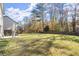 Extensive backyard showing lush green lawn, patio area, and wood fence with mature trees beyond at 1511 Arica Ave, Lawrenceville, GA 30043