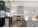 Bright kitchen with gray cabinets, granite countertops, stainless steel appliances, and island with breakfast bar at 1511 Arica Ave, Lawrenceville, GA 30043