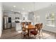 Bright kitchen features stainless steel appliances, gray cabinets, a wooden dining table and white subway tile backsplash at 1511 Arica Ave, Lawrenceville, GA 30043