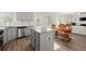 Open concept kitchen with gray cabinets, stainless appliances and granite counters flows into the living area at 1511 Arica Ave, Lawrenceville, GA 30043