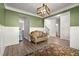 Cozy living room featuring green walls, white trim, and stylish decor with a large area rug at 1511 Arica Ave, Lawrenceville, GA 30043