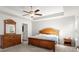 This main bedroom features a trey ceiling, fan, and wooden furniture at 1511 Arica Ave, Lawrenceville, GA 30043
