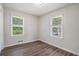 Well-lit bedroom with wood laminate flooring and two windows at 3204 Robin Rd, Decatur, GA 30032