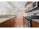 Galley kitchen featuring stainless steel appliances, granite countertops, and wood cabinets at 1538 Chantilly Ne Dr # 224, Atlanta, GA 30324