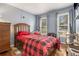 Cozy bedroom with wood floors, a warm red comforter, and natural light from dual windows at 4865 Fenbrook Dr, Stone Mountain, GA 30088
