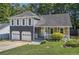 Charming two-story home featuring a stone facade, gray siding, shutters, a well-manicured lawn, and a two-car garage at 4865 Fenbrook Dr, Stone Mountain, GA 30088