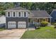 Charming two-story home featuring a stone facade, gray siding, shutters, a well-manicured lawn, and a two-car garage at 4865 Fenbrook Dr, Stone Mountain, GA 30088