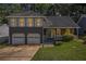 Charming two-story home featuring a stone facade, a covered porch, and a two-car garage at 4865 Fenbrook Dr, Stone Mountain, GA 30088
