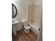 Bathroom with a tub, toilet, pedestal sink and wood-look flooring at 783 Fox Valley Dr, Stone Mountain, GA 30088