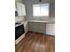 Traditional kitchen featuring bright white cabinets, a white dishwasher, and wood flooring at 783 Fox Valley Dr, Stone Mountain, GA 30088
