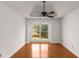 Bright bedroom with a large window offering views of the outdoors, tray ceilings, and hardwood floors at 100 Hall Pl, Fayetteville, GA 30215