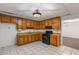 Cozy kitchen featuring wood cabinets, black appliances, and white tile flooring for a classic look at 100 Hall Pl, Fayetteville, GA 30215