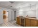 Kitchenette with wooden cabinets, a wine cooler, granite countertops and white tile flooring at 100 Hall Pl, Fayetteville, GA 30215