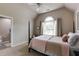 Cozy bedroom with a four-poster bed, arched window providing natural light, and a view of the ensuite bathroom at 285 Lackland Court, Sandy Springs, GA 30350