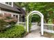 White garden gate with climbing vines leading to a secluded backyard patio at 285 Lackland Court, Sandy Springs, GA 30350