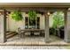 Covered patio featuring an outdoor dining table, grill, and hanging ferns at 285 Lackland Court, Sandy Springs, GA 30350