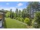 Expansive backyard featuring lush green lawn, manicured landscaping, and a covered patio at 8240 Sonata Ln, Cumming, GA 30041