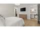 Stylish bedroom with hardwood floors, neutral tones, and a view into the bathroom creating a cohesive and comfortable living space at 8240 Sonata Ln, Cumming, GA 30041