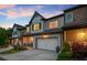 Charming townhouse exterior featuring a two-car garage, brick accents, and manicured landscaping for enhanced curb appeal at 8240 Sonata Ln, Cumming, GA 30041