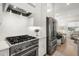 Kitchen with stainless steel gas range and appliances, white cabinetry, and hardwood floors at 8240 Sonata Ln, Cumming, GA 30041