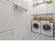 Well-organized laundry room with white cabinets, modern washer and dryer, and stylish tile flooring at 8240 Sonata Ln, Cumming, GA 30041