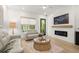Cozy living room with comfortable seating, fireplace, hardwood floors, and bright windows at 8240 Sonata Ln, Cumming, GA 30041