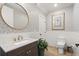 Stylish powder room with decorative wallpaper, wainscoting, and a gold round mirror at 8240 Sonata Ln, Cumming, GA 30041
