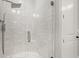 Sleek glass enclosed shower with mosaic tile floors and white tile walls for a bright and modern aesthetic at 8240 Sonata Ln, Cumming, GA 30041