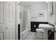 Bathroom featuring black and white tile, tub with shower, and pedestal sink at 184 Rambo Sw Pl, Marietta, GA 30064