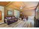 Cozy sun room with wood paneled walls, ceiling fan, brick fireplace, and comfortable leather sofas at 184 Rambo Sw Pl, Marietta, GA 30064