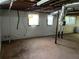 Unfinished basement with vapor barrier, exposed ceiling and two windows at 185 W Lake Nw Dr, Atlanta, GA 30314