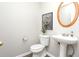 Small half bathroom featuring pedestal sink, updated flooring, and modern decor at 2447 Stancrest Ln, Lawrenceville, GA 30044