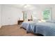 Cozy bedroom featuring two twin beds, wood-look flooring, and natural light from the bright window at 5170 Oxbow Rd, Stone Mountain, GA 30087
