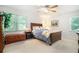 Cozy bedroom with a queen sized bed, ceiling fan, and natural light from two large windows at 5170 Oxbow Rd, Stone Mountain, GA 30087