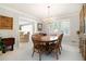 Elegant dining room with a wooden table, six chairs, a chandelier, and bright windows at 5170 Oxbow Rd, Stone Mountain, GA 30087