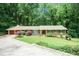 Inviting single-story brick home featuring a well-manicured lawn, mature trees, and a spacious two-car garage at 5170 Oxbow Rd, Stone Mountain, GA 30087