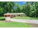 Charming home boasts a lush, green lawn and a circular driveway surrounded by mature trees at 5170 Oxbow Rd, Stone Mountain, GA 30087