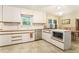 Bright kitchen with white cabinetry, tile floors, a center island, and adjacent dining area at 5170 Oxbow Rd, Stone Mountain, GA 30087