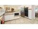 Bright kitchen with white cabinetry, stainless steel appliances, tile floors, and a dining area at 5170 Oxbow Rd, Stone Mountain, GA 30087