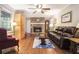 Comfortable living room with a brick fireplace, ceiling fan, wood floors, and a leather sofa at 5170 Oxbow Rd, Stone Mountain, GA 30087