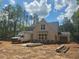New home construction with covered porch, windows, and a wooded backdrop under a bright sky at 6821 Phillips Mill Rd, Douglasville, GA 30135