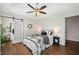 Bedroom with tray ceiling, ceiling fan, hardwood floors, and sliding barn door access to the bathroom at 1857 Barrington Ct, Marietta, GA 30066