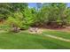Large backyard with a firepit and seating surrounded by trees at 2173 Beacon Crest Dr, Buford, GA 30519