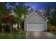 Charming two-story home features a well-maintained lawn, attached two-car garage, and mature landscaping at twilight at 2173 Beacon Crest Dr, Buford, GA 30519