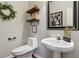Stylish half bathroom with floating shelves, modern fixtures, and elegant decor at 2173 Beacon Crest Dr, Buford, GA 30519