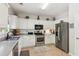 Well-lit kitchen with stainless steel appliances, white cabinetry, and ample counter space at 2173 Beacon Crest Dr, Buford, GA 30519