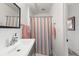 This bathroom features a stylish vanity, framed mirror, and a shower with a colorful striped curtain at 220 Sisson Ne Ave, Atlanta, GA 30317