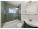 Well-lit bathroom features modern green tile, glass shower door, and floating shelves at 220 Sisson Ne Ave, Atlanta, GA 30317