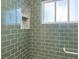 Up-close view of a shower showcasing modern green tile, niche, and glass door in a stylish bathroom at 220 Sisson Ne Ave, Atlanta, GA 30317